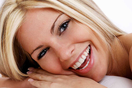 Portrait picture of a smiling woman with long blonde hair and beautiful teeth, happy with her cosmetic dental procedure she had with the Dental Center of Costa Rica, San Jose, Costa Rica.